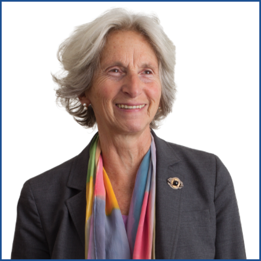 Headshot of a gray-haired woman wearing a blazer and a multicolored scarf