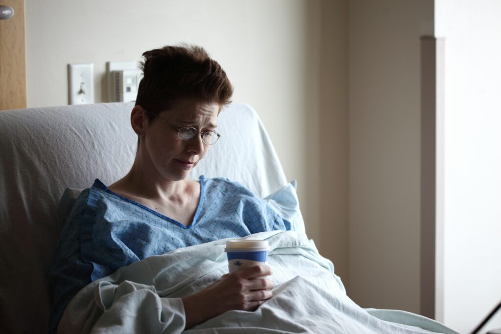 Person in hospital bed drinking coffee